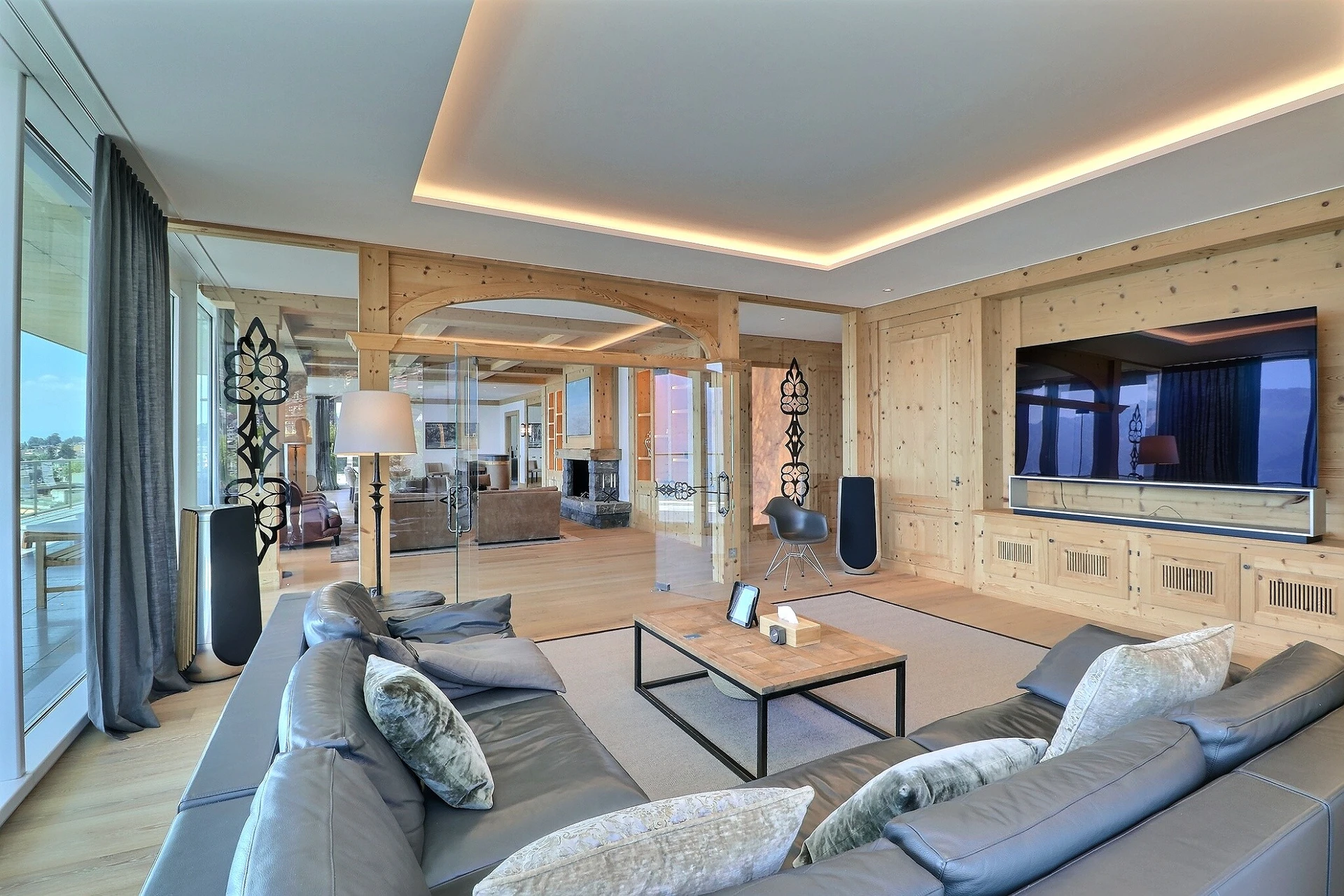 Helles, modernes Wohnzimmer mit Holzverkleidung und großem TV