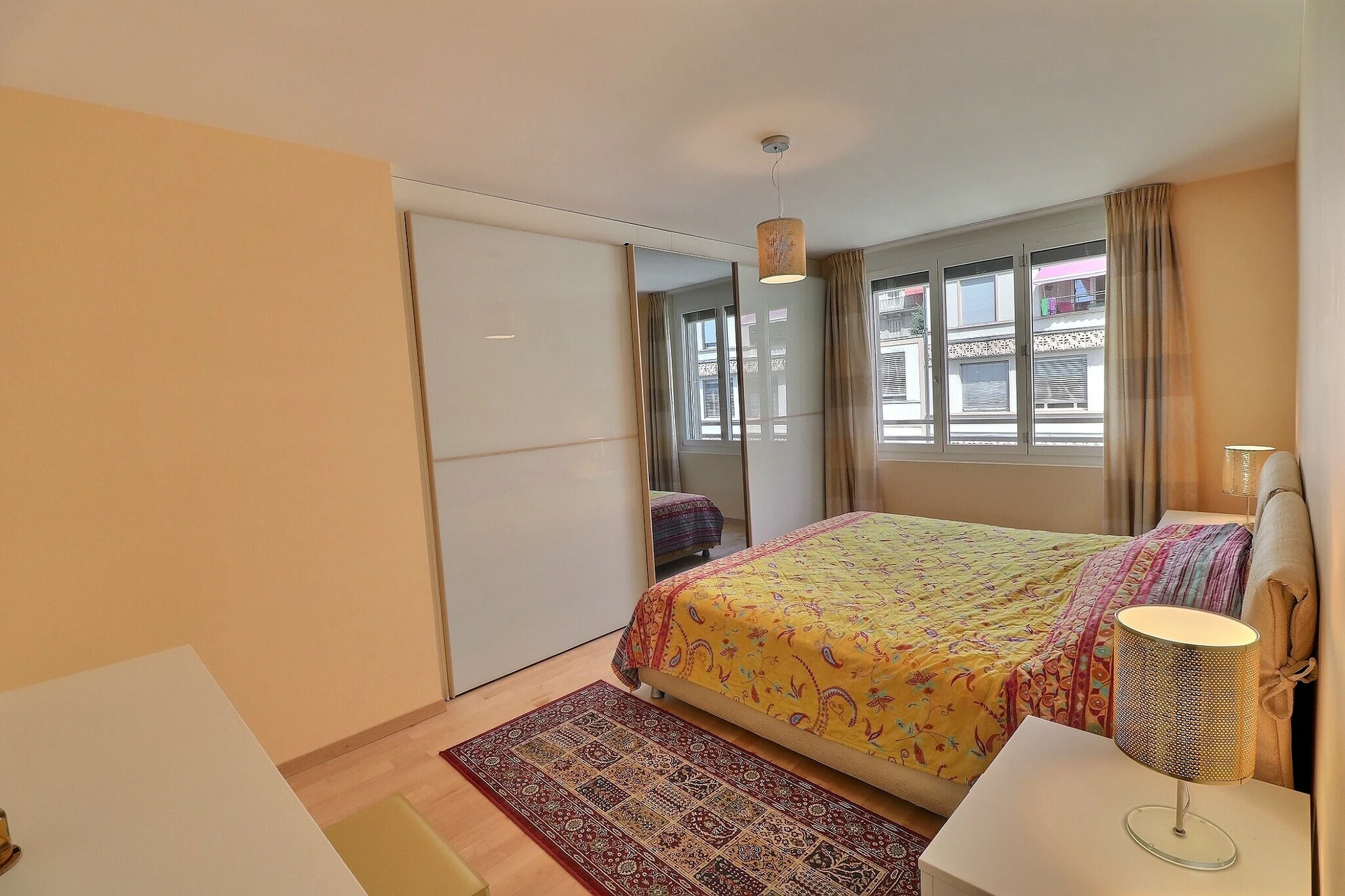 Helles Schlafzimmer mit Fensterfront und Schiebetürenschrank