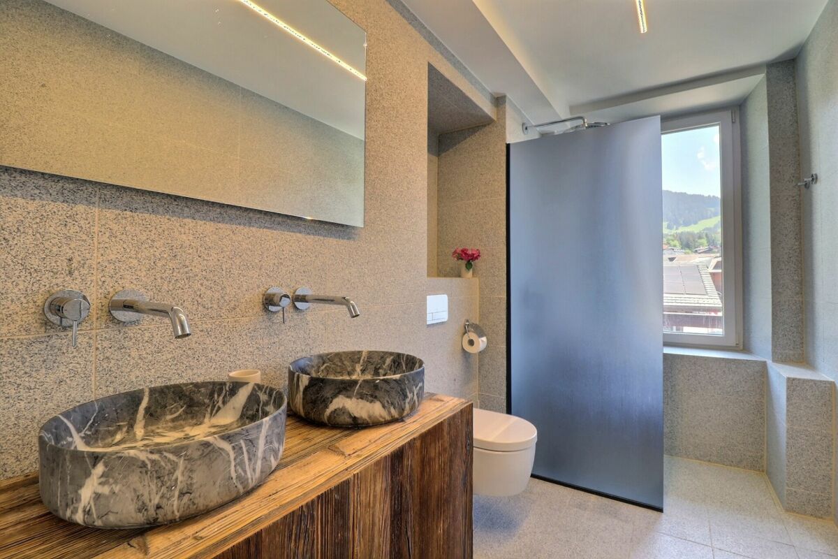 Modernes Badezimmer mit Doppelwaschtisch und Fensterblick