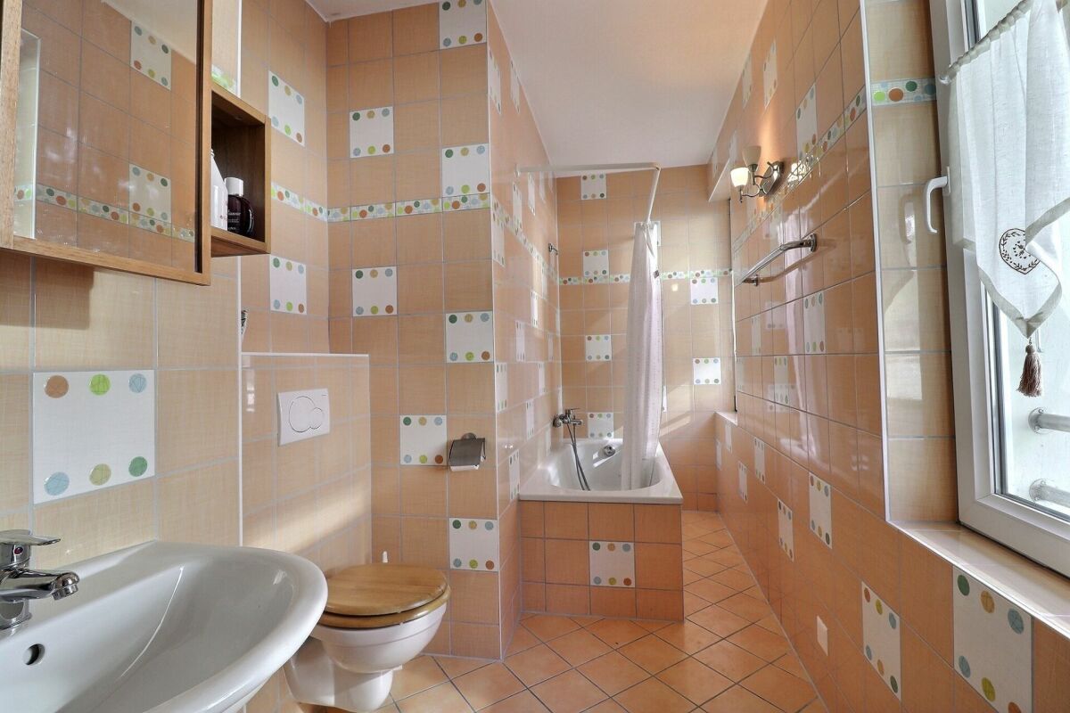 Bunt gefliestes Badezimmer mit Badewanne und Waschbecken