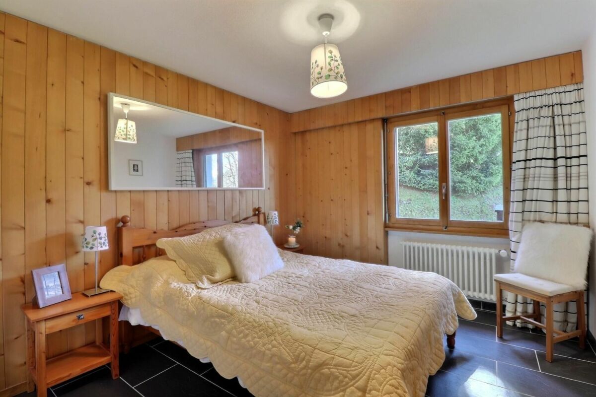 Gemütliches Schlafzimmer mit Holzvertäfelung