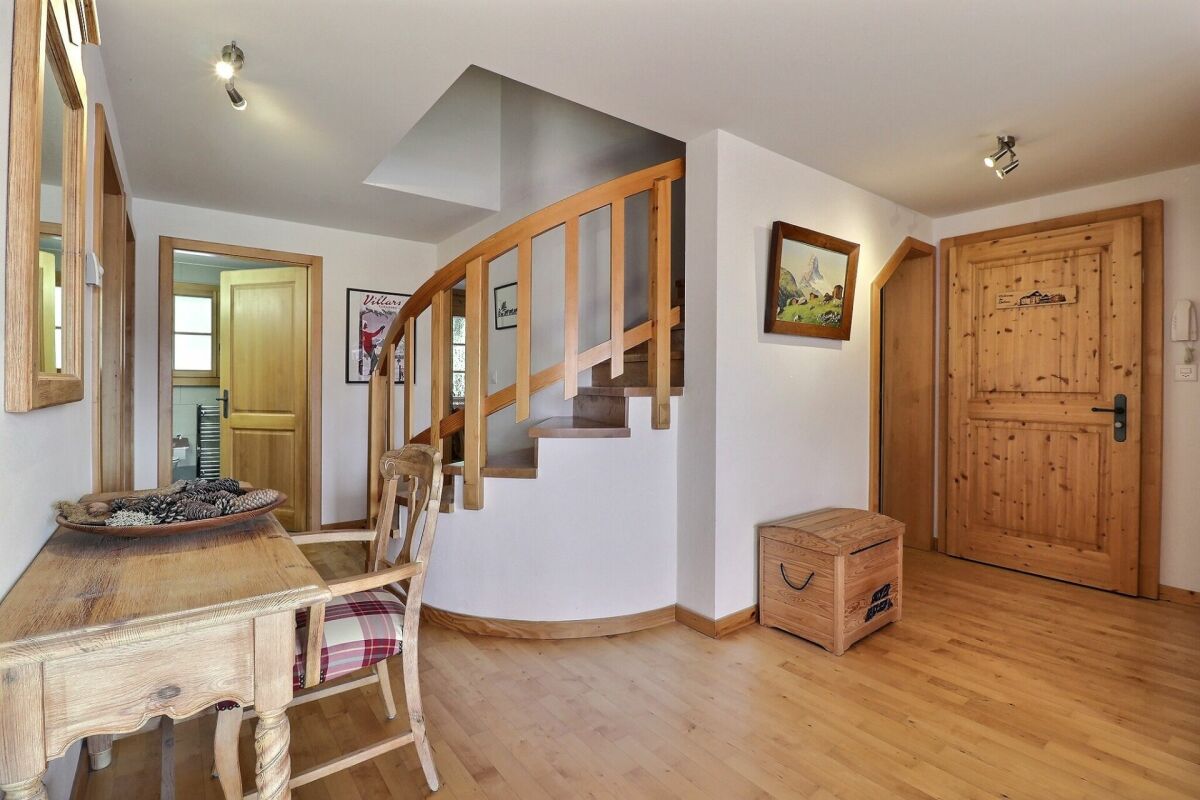 Heller Eingangsbereich mit Holztreppe