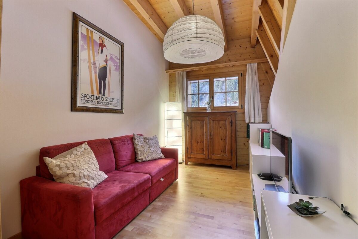 Gemütlicher Dachraum mit Sofa und Holzdecke