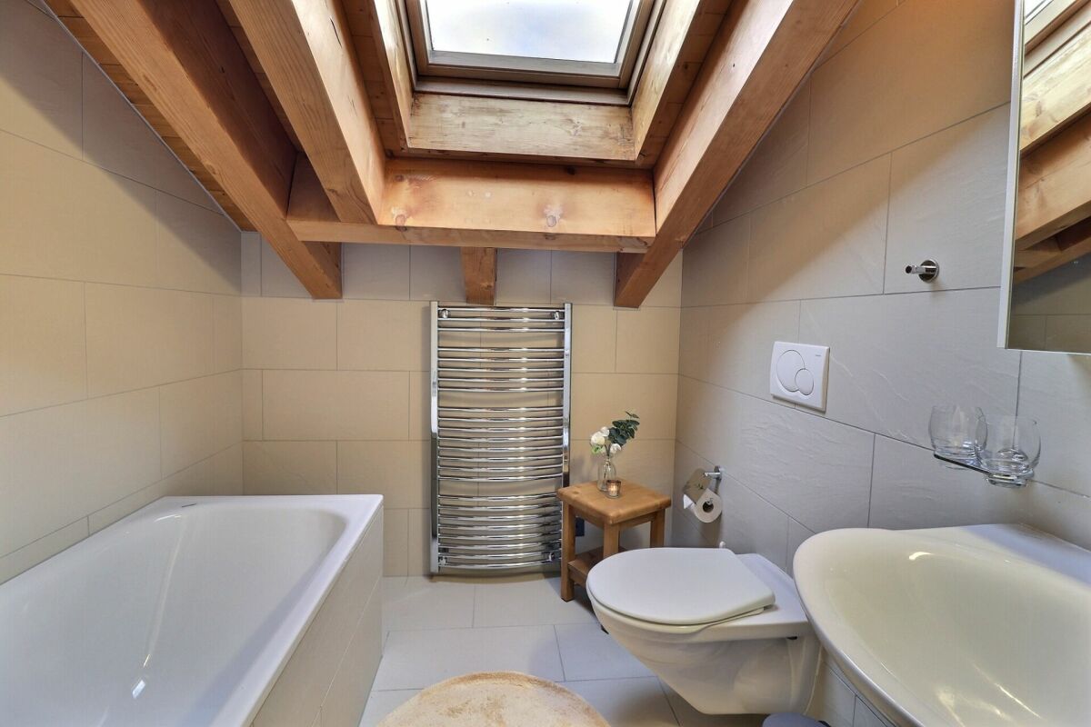 Dachbadezimmer mit Badewanne und WC