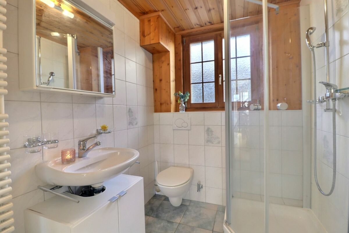 Helles Badezimmer mit Holzverkleidung und Dusche