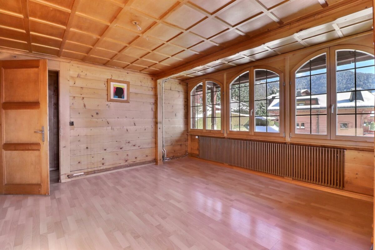 Holzverkleideter Raum mit großen Rundbogenfenstern