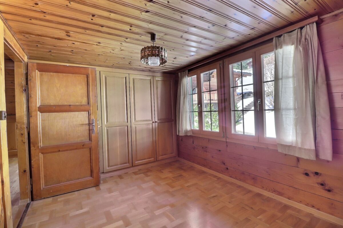 Holzvertäfelter Raum mit Fenstern und Einbauschrank
