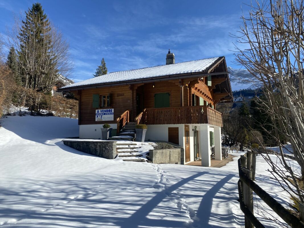Alpenchalet im Schnee mit Verkaufsschild