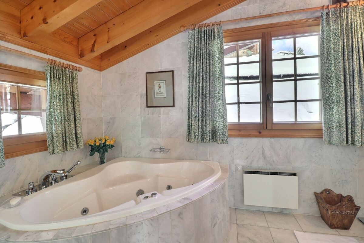 Luxuriöses Badezimmer mit Whirlpool-Badewanne und Holzdecke