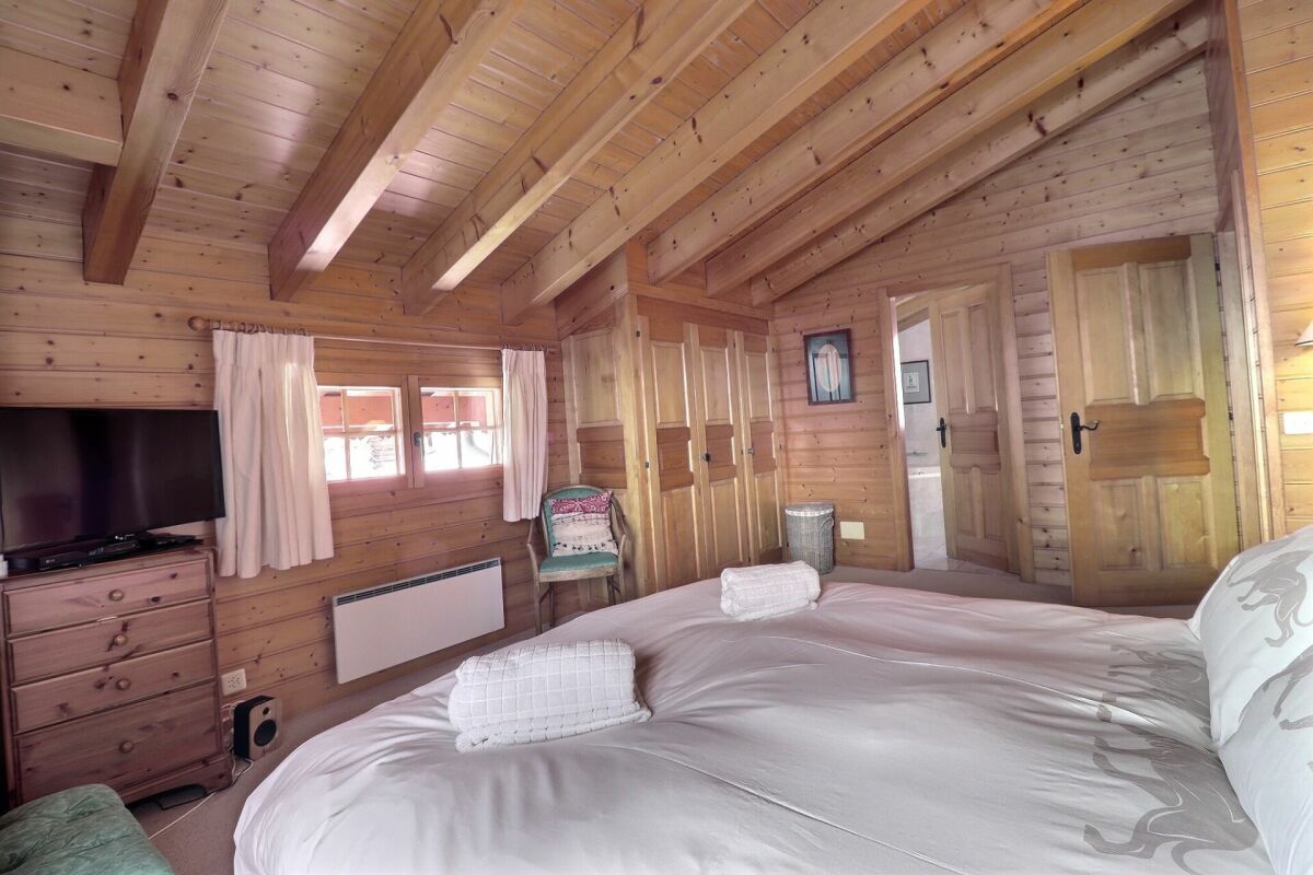 Holzschlafzimmer mit sichtbaren Dachbalken