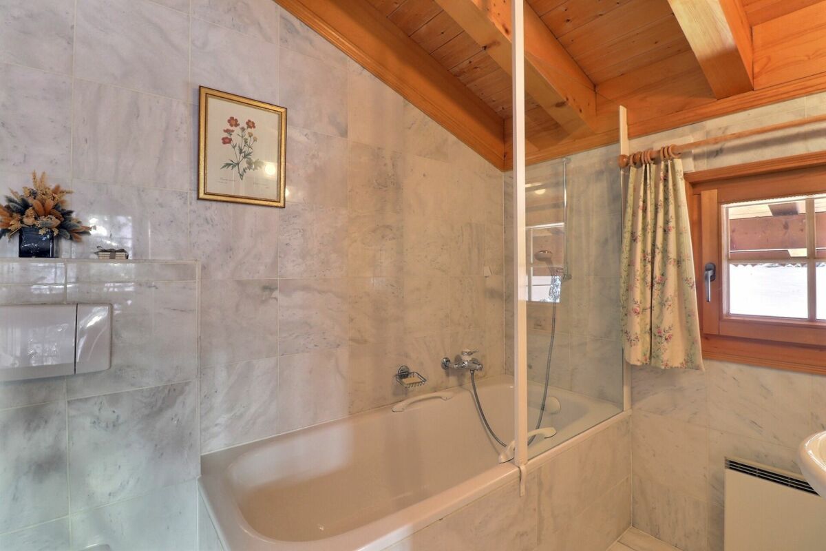 Badezimmer mit Badewanne und Holzdecke