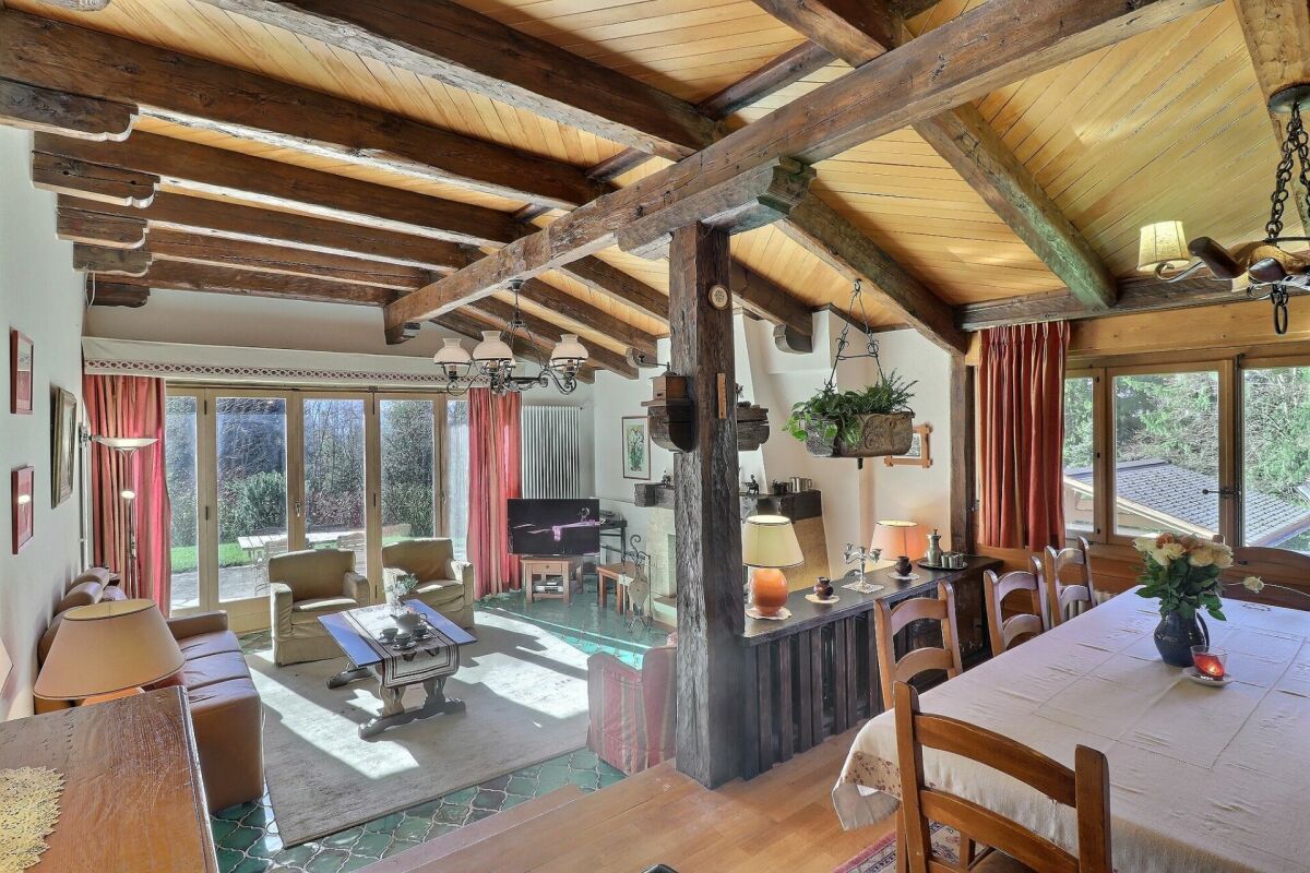 Rustikales Wohnzimmer mit Essbereich und sichtbaren Holzbalken