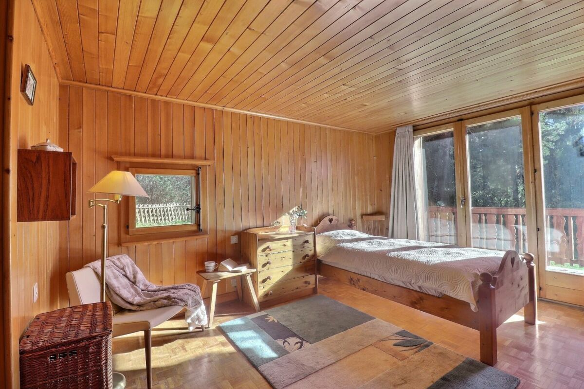 Holzverkleidetes Schlafzimmer mit Balkonblick