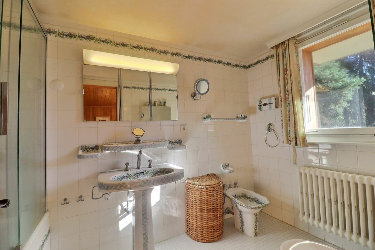 Badezimmer mit Fliesen, Waschbecken und Fenster