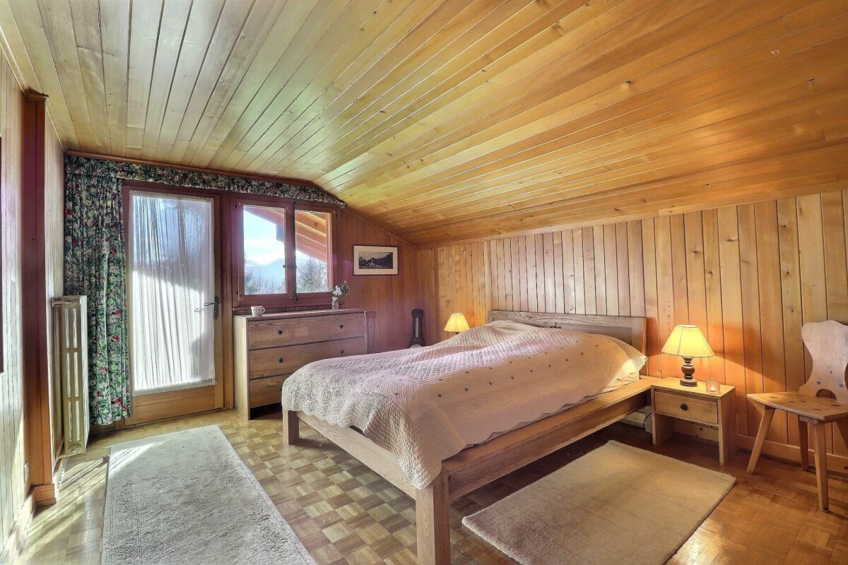 Gemütliches Schlafzimmer mit Holzverkleidung und Dachschräge