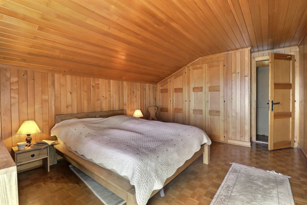 Dachgeschoss-Schlafzimmer mit viel Holzverkleidung