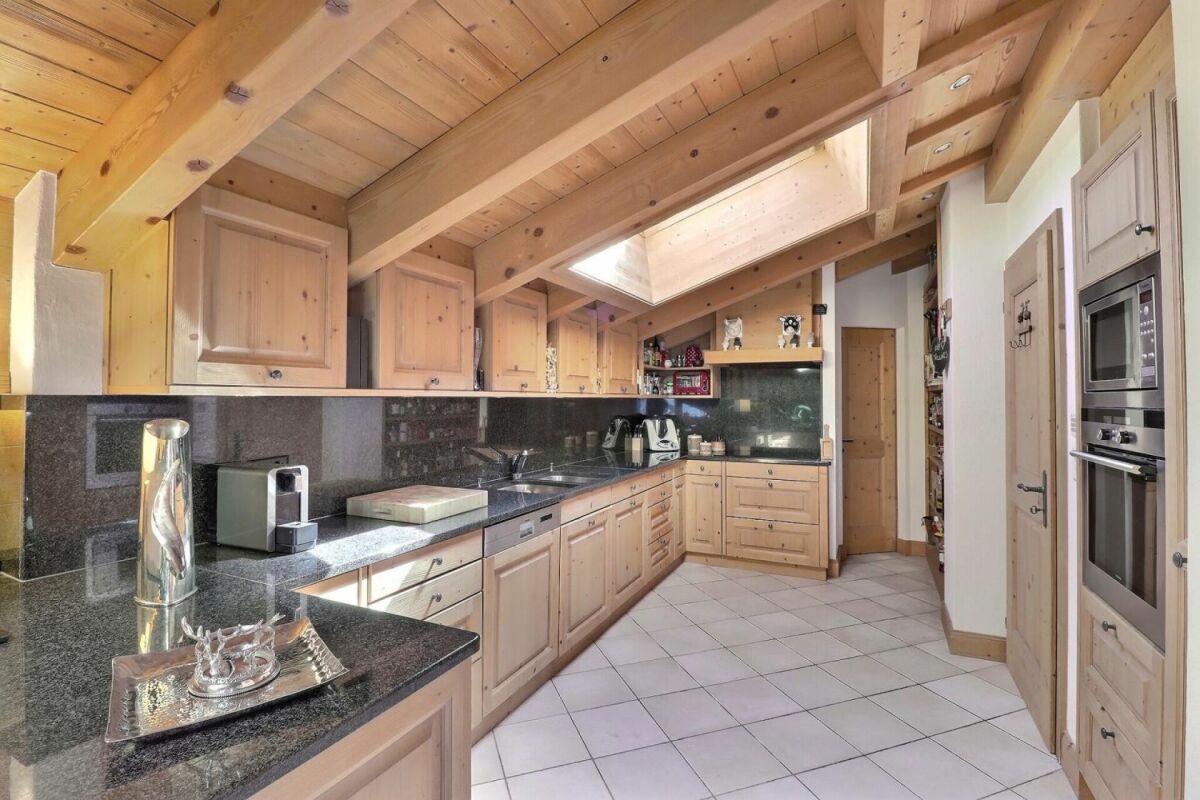 Helle Landhausküche mit Holzoptik und dunkler Arbeitsfläche