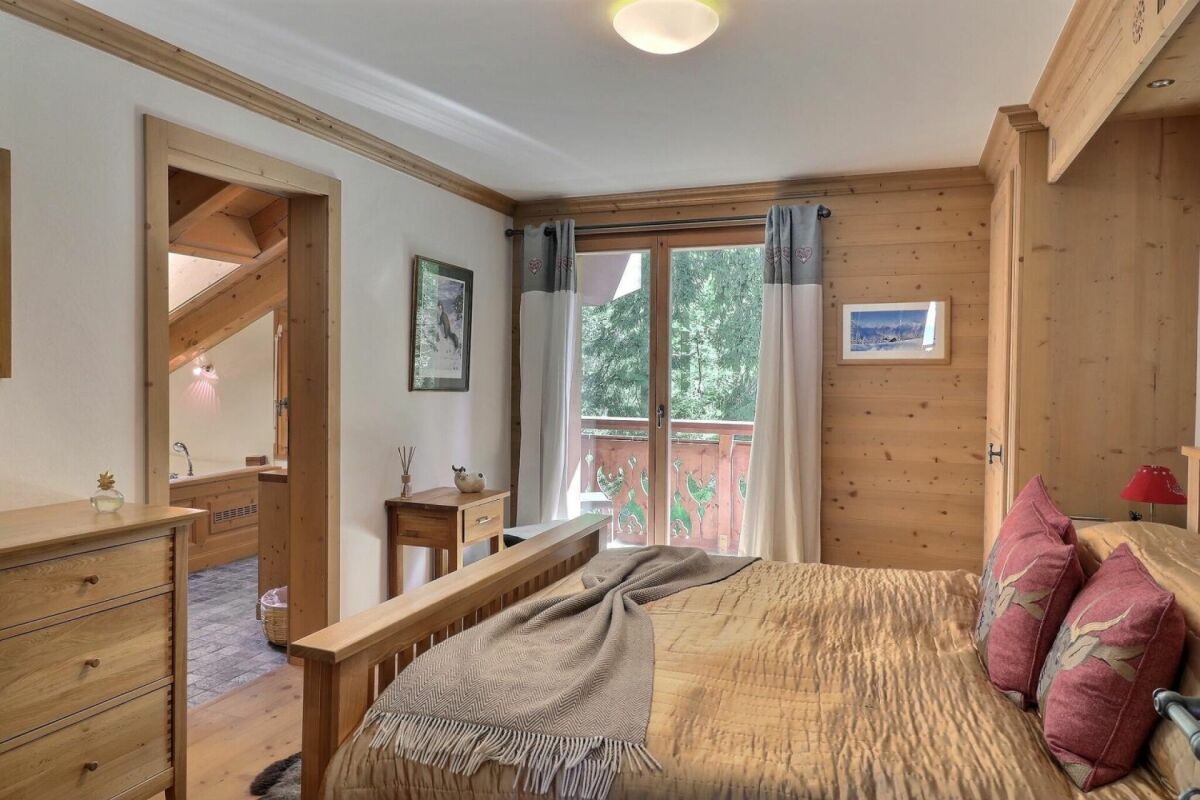 Gemütliches Schlafzimmer mit Holzausstattung und Balkonblick