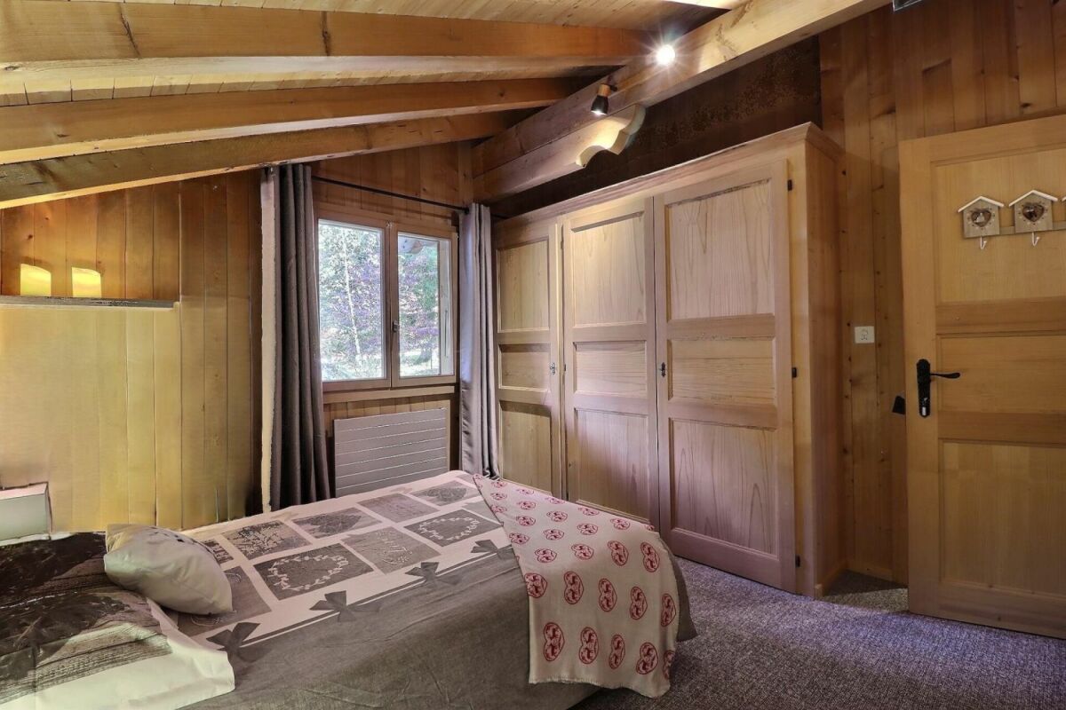 Rustikales Schlafzimmer mit Holzverkleidung