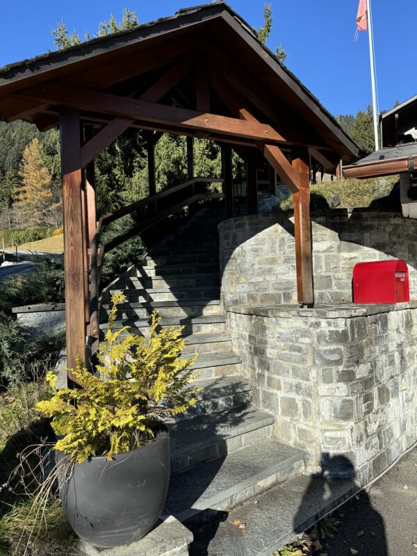 Bergige Außenansicht mit Steintreppe und Holzüberdachung