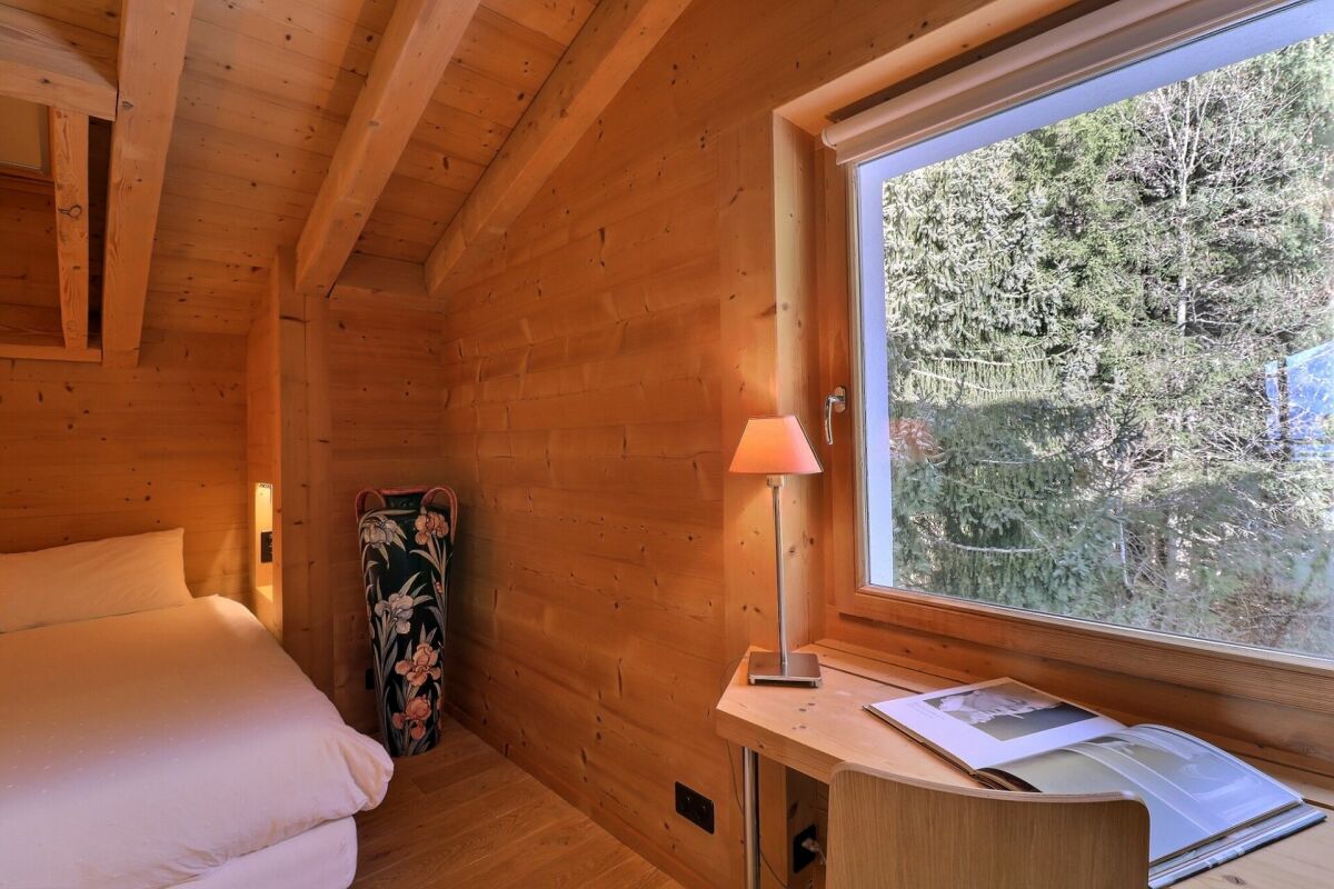 Gemütliches Holzzimmer mit Bett und Fensterblick