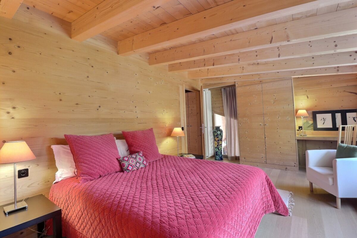 Holzvertäuschtes Schlafzimmer mit pinkem Bett