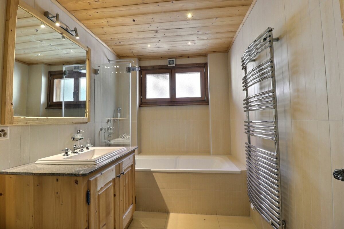 Badezimmer mit Holzdecke und Badewanne