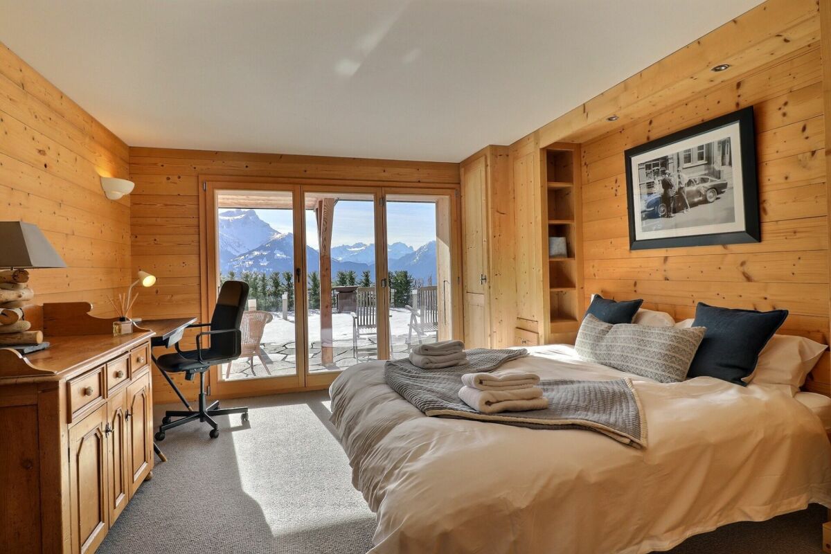 Schlafzimmer im alpinen Holzstil mit Bergblick