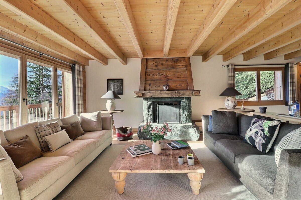 Gemütliches Wohnzimmer im Chalet-Stil mit Kamin und Bergblick