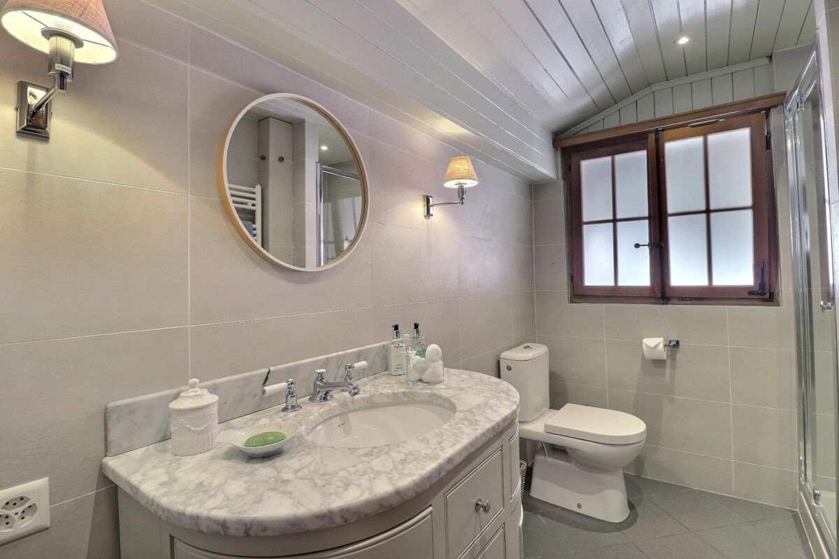 Helles Badezimmer mit Marmorwaschtisch und Fenster