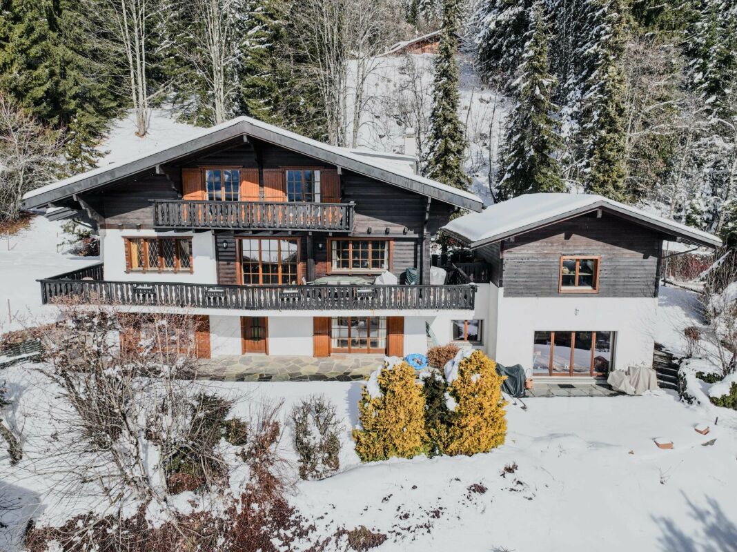Schneebedecktes Chalet mit mehreren Balkonen