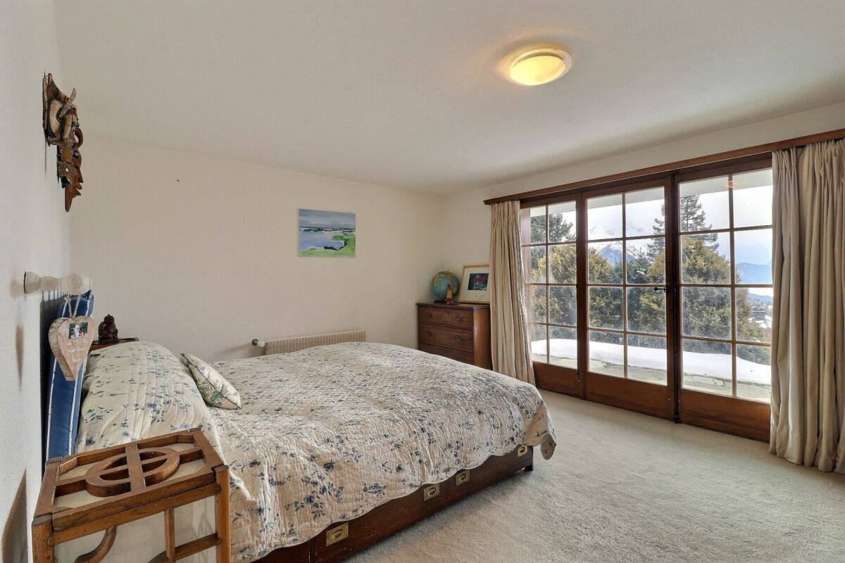Helles Schlafzimmer mit Balkon- oder Terrassentür und Bergblick