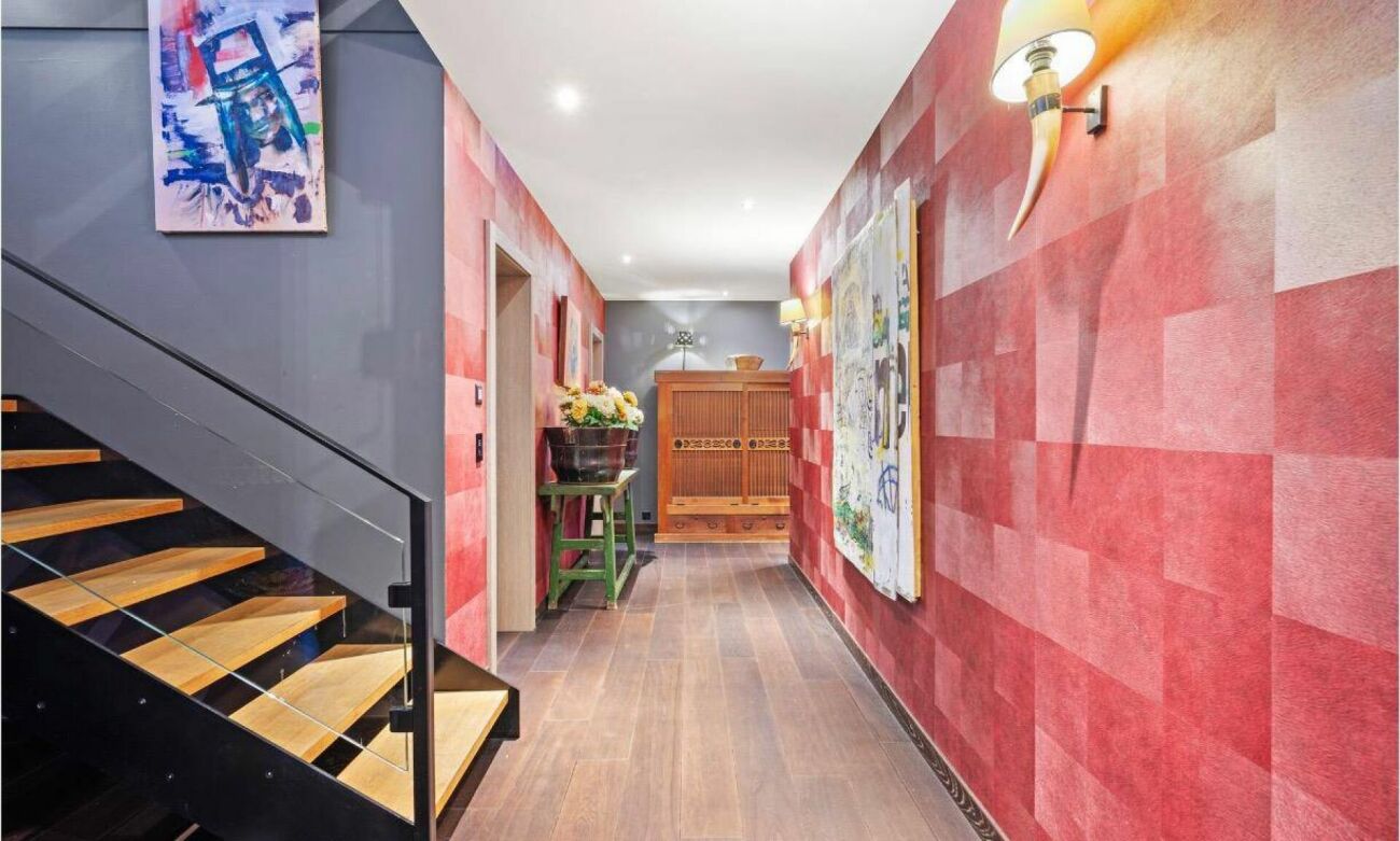 Modern gestalteter Flur mit Treppe und Kunstwerken