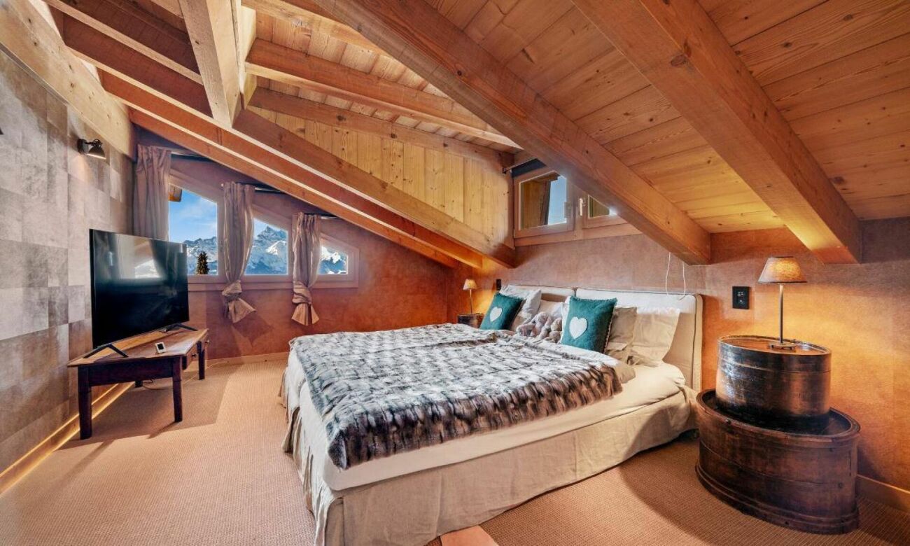 Gemütliches Dachschlafzimmer mit Holzdecke und Bergblick