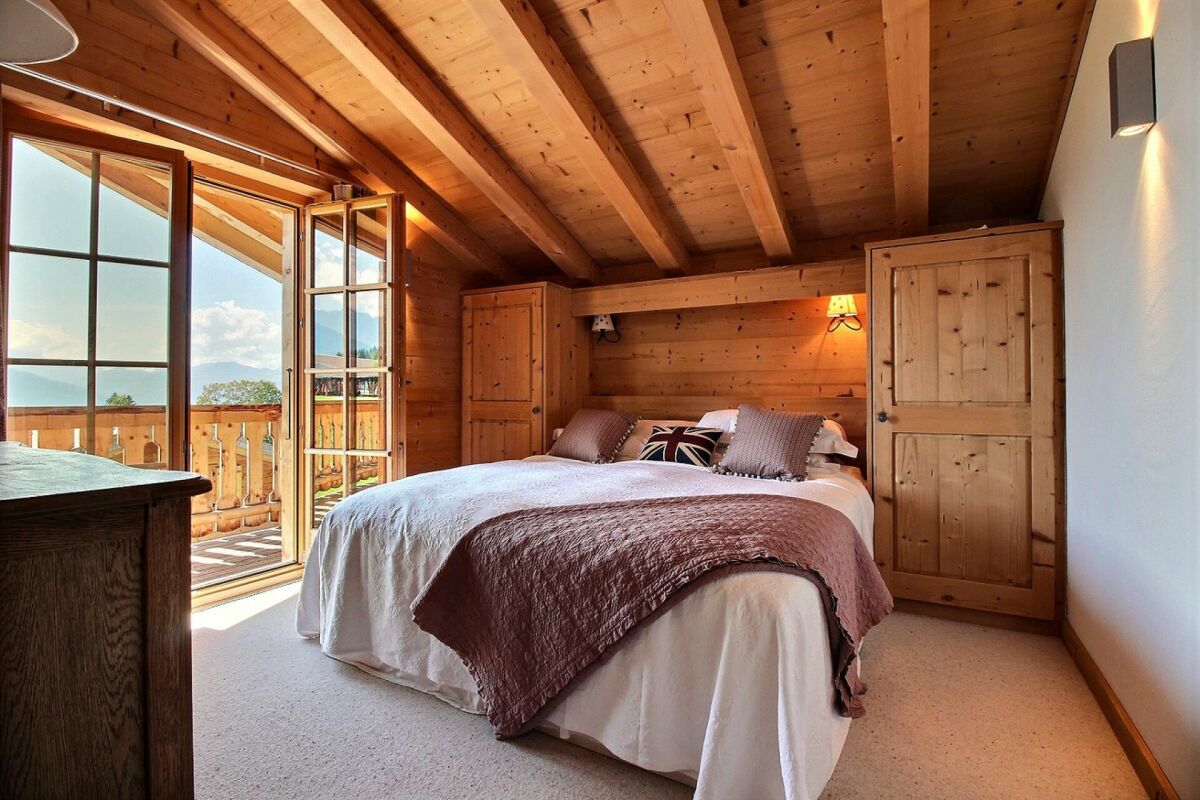 Gemütliches Holz-Schlafzimmer mit Balkonblick