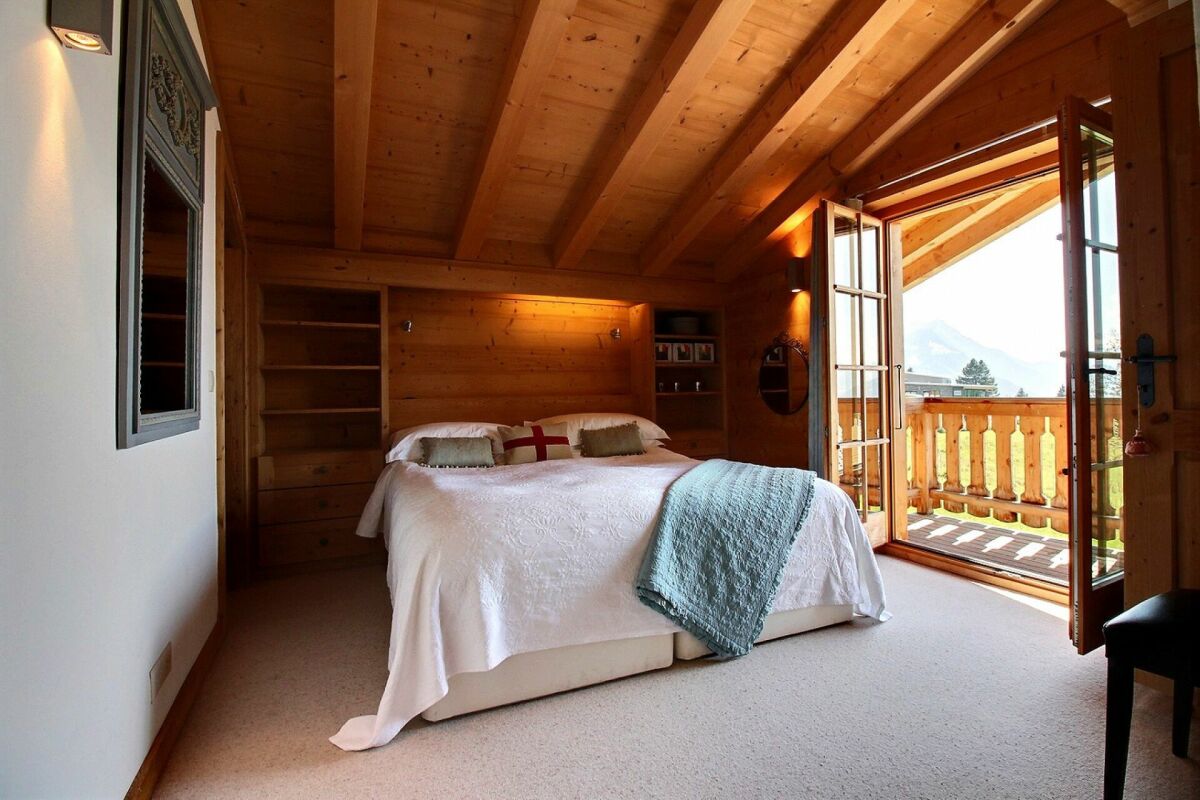 Gemütliches Schlafzimmer im Holzhaus mit Balkon