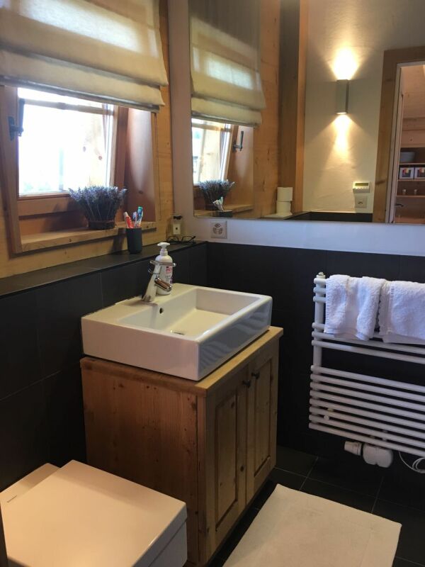 Modernes Bad mit Holz- und Schwarzkontrasten