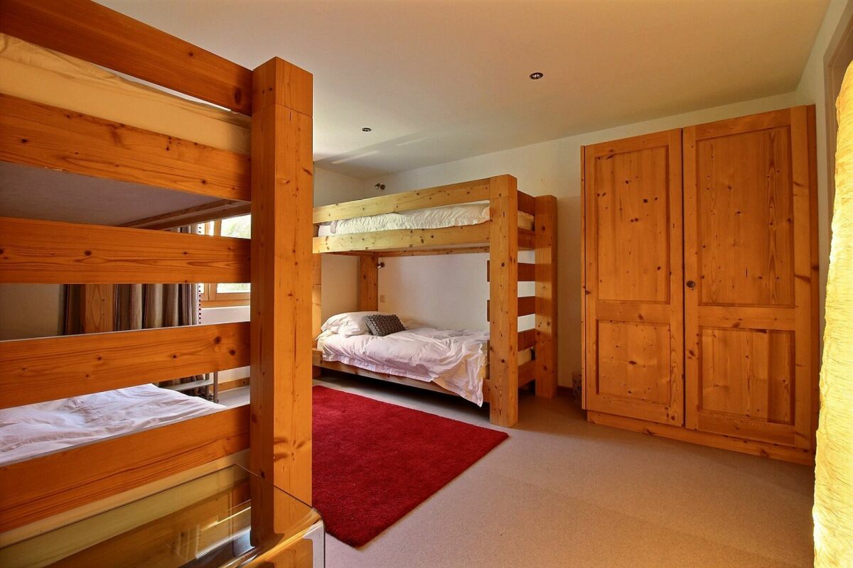 Schlafzimmer mit Holz-Etagenbett und Kleiderschrank