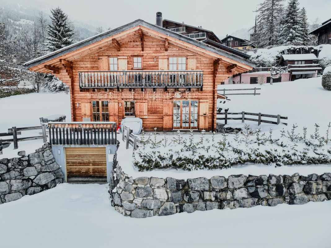 Schneebedecktes Holzchalet mit Balkon