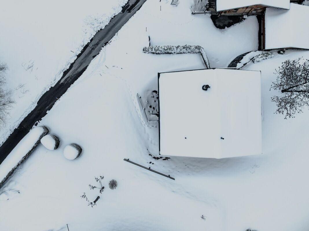 Verschneite Luftaufnahme eines Hauses mit Hof