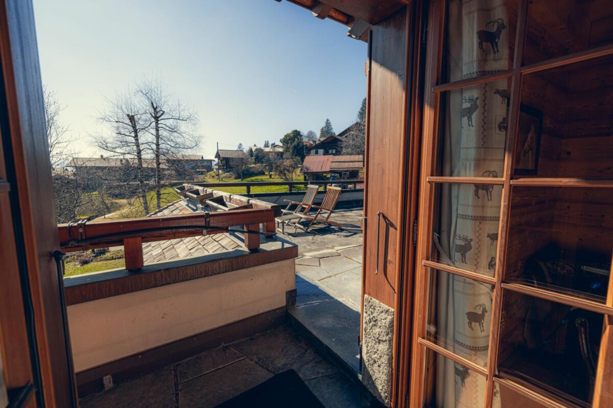 Blick vom Balkon auf eine sonnige Terrasse und das Umland