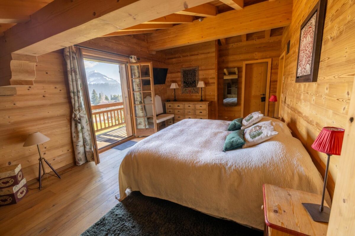 Gemütliches Chalet-Schlafzimmer mit Balkonblick