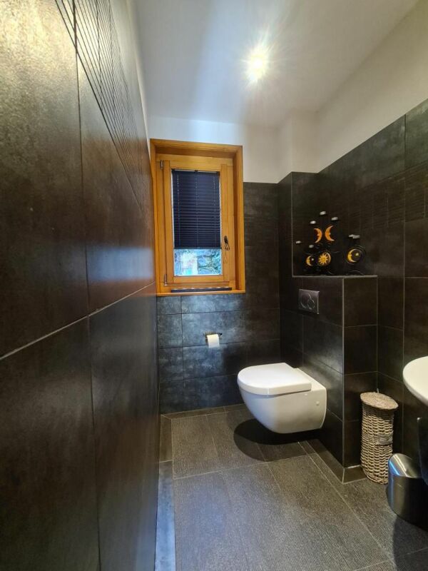 Modernes Gäste-WC mit dunkler Wandverkleidung
