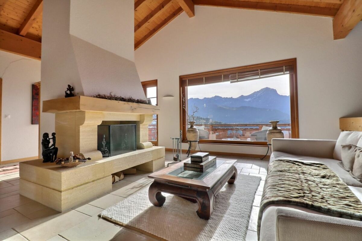 Wohnzimmer mit Kamin und Bergblick