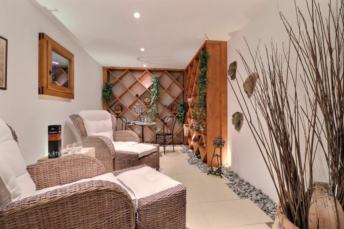 Gemütliche Lounge mit Weinregal und Rattansesseln