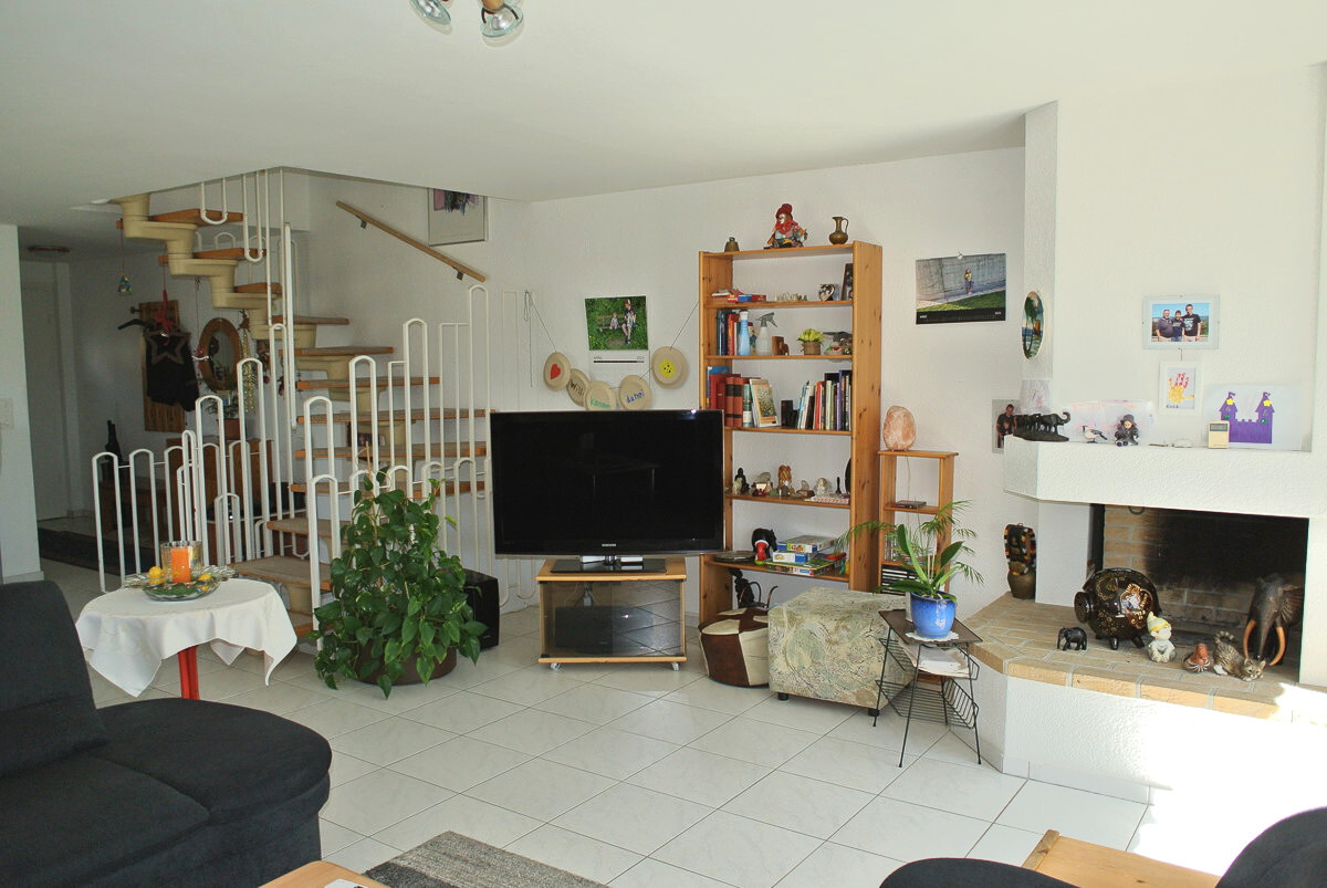Wohnzimmer mit Kamin und Treppe