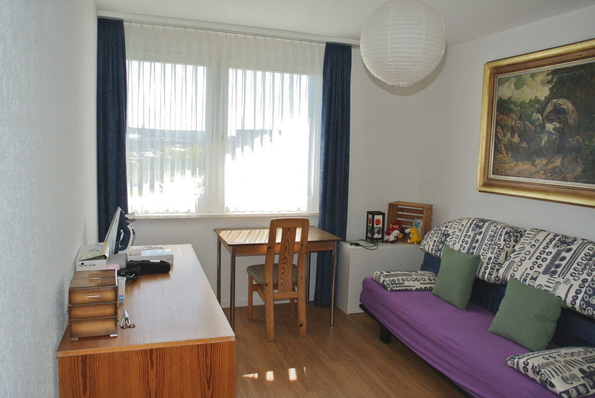 Kleines Wohn- oder Arbeitszimmer mit Sofa und Schreibtisch
