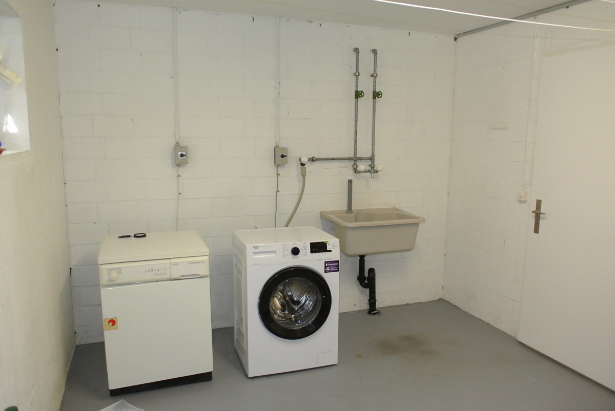 Hauswirtschaftsraum mit Waschmaschine und Spülbecken