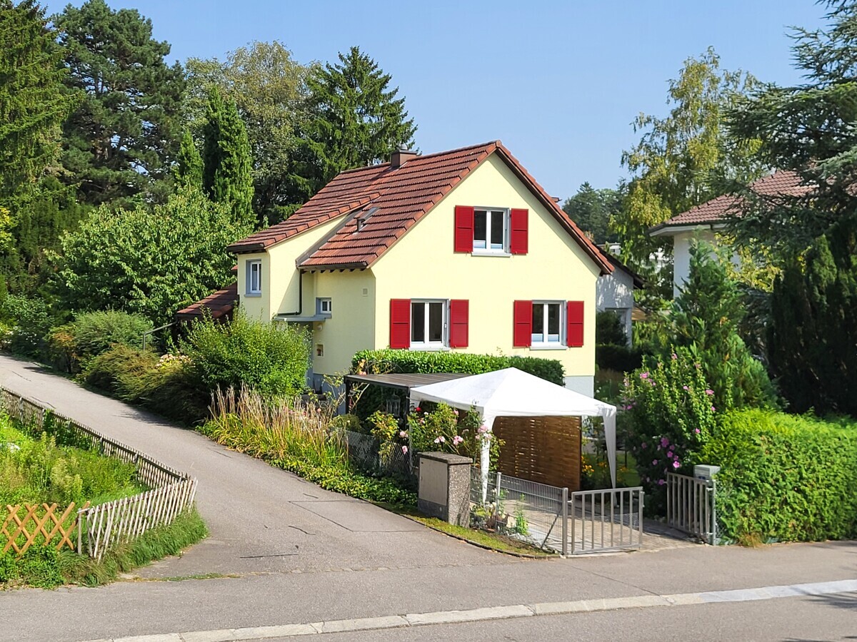 Einfamilienhaus mit rotem Ziegeldach und Garten