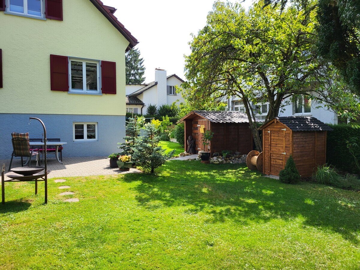 Gartenansicht eines Wohnhauses mit Nebengebäuden